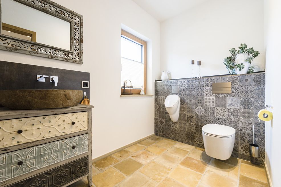 Badezimmer mit Fliesen in Zementoptik und rustikaler Einrichtung.