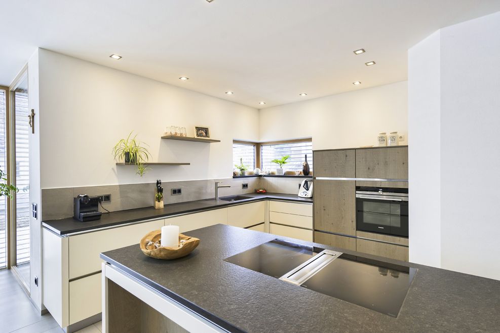 Offene Küche mit Kochinsel und einer dunklen Arbeitsplatte