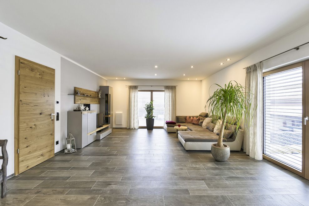 Großer Wohnbereich mit braun, grauen Fliesen