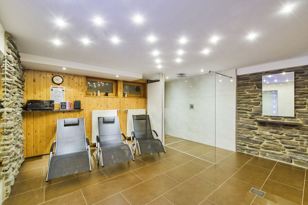 Gefliester Saunabereich mit braunen und weißen Fliesen und Naturstein Mauerverblendung