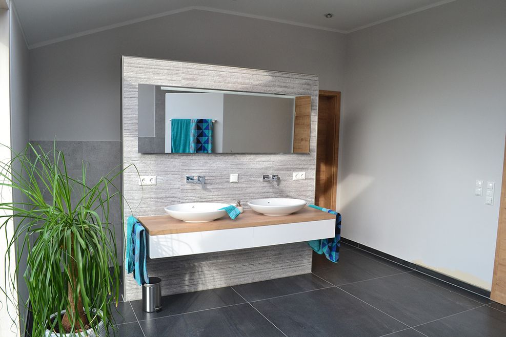 Modernes Doppelwaschbecken mit Unterschrank und Wandspiegel im Badezimmer.